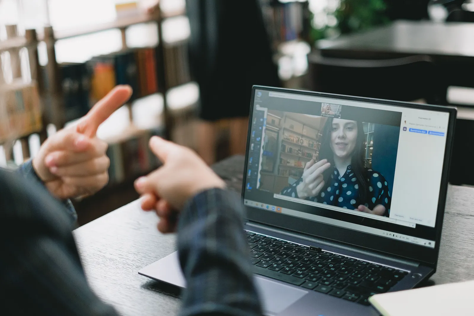 Videochamada em notebook mostrando duas pessoas se comunicando em língua de sinais